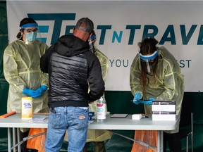 Edmonton Elks fans get rapid COVID-19 tests at Test n Travel's booth outside Commonwealth Stadium in Edmonton, on Friday, Oct. 15, 2021.