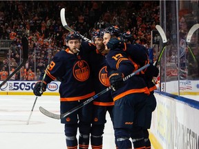 Edmonton Oilers' Connor McDavid (97) celebrates a goal with teammates on Calgary Flames goaltender Jacob Markstrom (25) during first period NHL action at Rogers Place in Edmonton, on Saturday, Oct. 16, 2021.
