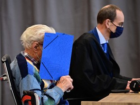 Defendant Josef S. sits next to his lawyer, Stefan Waterkamp, and hides his face behind a folder as he waits for the start of his trial in Germany. He is oldest person yet to be tried for Nazi-era crimes.