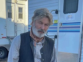 Alec Baldwin posted a picture of himself on Instagram sporting a grey beard and dressed in Western cowboy-style attire in front of trailers on the set of Rust.