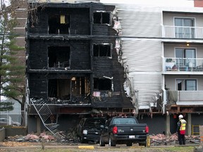 A security guard at the scene of a fire at 8630 106 Ave. in Edmonton on Saturday, Oct. 23, 2021.