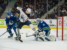 Vancouver Canucks defenceman Tyler Myers (57) looks to pounce on a rebound as goalie Thatcher Demko (35) makes a save on Edmonton Oilers forward Warren Foegele (37) at Rogers Arena on Saturday, Oct. 9, 2021.