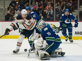 Vancouver Canucks goalie Thatcher Demko (35) makes a save as forward Bo Horvat (53) checks Edmonton Oilers forward Zach Hyman (18) at Rogers Arena on Oct 9, 2021.