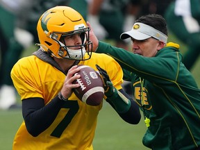 Edmonton Elks quarterback Trevor Harris (left) evades a tackle from head coach Jaime Elizondo at team practice in Edmonton on Oct. 5, 2021.