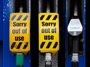 "Sorry out of use" signs are displayed on the fuel pumps at a closed filling station in Streatham Hill, south London, on Oct. 2, 2021.