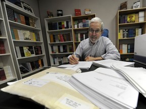 As NeWest Press founder and president, Douglas Barbour looks over manuscripts in his Edmonton office.
