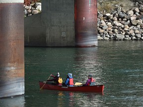 Three share a canoe as they head down the North Saskatchewan River underneath the James McDonald Bridge in Edmonton, October 2, 2021. Ed Kaiser/Postmedia