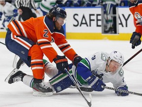 Oct 7, 2021; Edmonton, Alberta, CAN; Edmonton Oilers defensemen Duncan Keith (2) trips up Vancouver Canucks defensemen  Jack Rathbone (3) during the second period at Rogers Place. Mandatory Credit: Perry Nelson-USA TODAY Sports