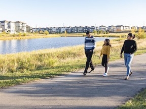 Sandeep Singla and Bhawana Aggarwal walk with their nine-year-old daughter Kanishka near their new home in Laurel Crossing.