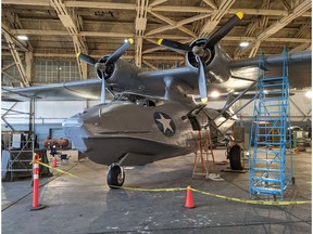 Boundary Bay, B.C. -- A Second World War-era Canso airplane restored by a group of farmers in Fairview, AB, gets a new paint job for a film shoot at a hangar in Boundary Bay. B.C. in September 2021. The plane was repainted in Second World War colours and insignias for a time travelling episode of DC's Legends of Tomorrow