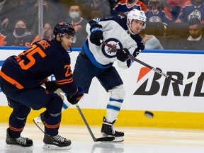 Darnell Nurse #25 of the Edmonton Oilers battles against Nikolaj Ehlers #27 of the Winnipeg Jets during the third period at Rogers Place on November 18, 2021.