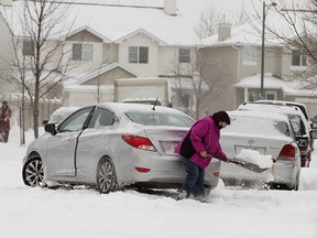 A motorist digs out their vehicle near 34 Avenue and Tamarack Green, in Edmonton on Tuesday Nov. 16, 2021, during a week when emergency calls for chest pain and cardiac arrest reached their highest level since the first week of October, according to AHS data.