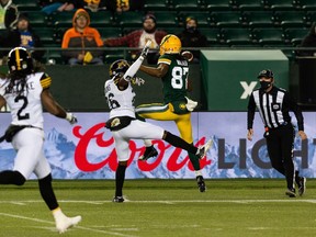 Edmonton Elks' Derel Walker (87) misses a catch as Hamilton Tiger-Cats' Cariel Brooks (26) reaches for a block during first half CFL action at Commonwealth Stadium in Edmonton, on Friday, Oct. 29, 2021.