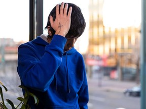 Pacey Dumas, seen on Tuesday, Nov. 2, 2021, holds his head where an Edmonton Police Service officer allegedly kicked him, leaving a hole in his skull.