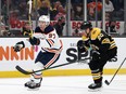 Edmonton Oilers center Connor McDavid (97) gloves the puck down behind Boston Bruins center Curtis Lazar (20) during the second period at TD Garden on Nov. 11, 2021.