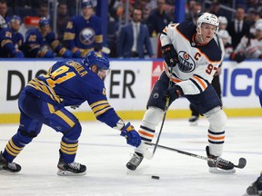 Buffalo Sabres center Drake Caggiula (91) tries to block a pass by Edmonton Oilers center Connor McDavid (97) during the third period at KeyBank Center on Nov. 12, 2021.