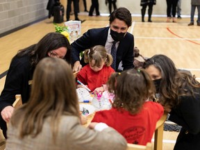 Prime Minister Justin Trudeau (top) is seen YMCA Shirley Stollery Child Care kids and their educators along with Karina Gould, (left) Minister of Families, Children and Social Development, Chrystia Freeland, (right), Minister of Finance of Canada, during a joint federal-provincial announcement of $10-a-day daycare at Boyle Street Plaza in Edmonton, on Monday, Nov. 15, 2021.