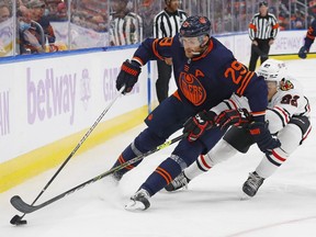 Edmonton Oilers forward Leon Draisaitl (29) carries the puck around Chicago Blackhawks defensemen Caleb Jones (82) during the third period at Rogers Place.