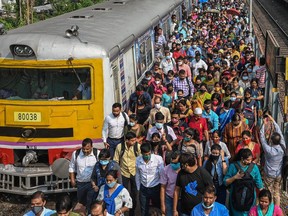 Commuters walk along a railway platform after stepping out from a suburban local train in Kolkata on Nov. 1, 2021 as train services returned to normal.