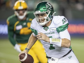 Saskatchewan Roughriders quarterback Cody Fajardo (7) runs the ball under pressure from Edmonton Elks' Chris Nelson (92) in Edmonton on Friday, Nov. 5, 2021.