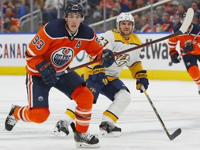 Edmonton Oilers forward Ryan Nugent-Hopkins (93) and Nashville Predators forward Rocco Grimaldi (23) look for a loose puck at Rogers Place on Wednesday, Nov 3, 2021.