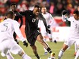 Forward Cyle Larin (17) tries to get past Mexico defender Julio Dominguez (3) during the first half of their World Cup Qualifier soccer match on Tuesday.