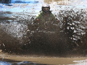 An off roader hits a mud puddle on an ATV at McLean Creek, a popular camping and offroad use area west of Calgary. File photo.
