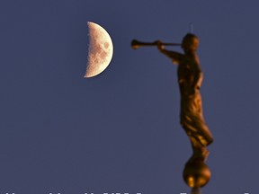 The waxing crescent moon at 41% exposed, starts to rise behind a golden statue as the sun starts to set in west Edmonton, November 10, 2021. Ed Kaiser/Postmedia