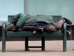 A vulnerable person sleeps on a bench in downtown Edmonton on Friday May 28, 2021.