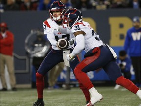 Montreal Alouettes quarterback Trevor Harris hands off to tailback William Stanback during the first half against the Winnipeg Blue Bombers in Winnipeg on Nov. 6, 2021.