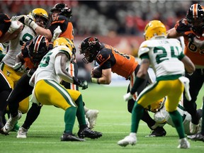 B.C. Lions quarterback Nathan Rourke (12) is tackled by Edmonton Elks' Derrick Moncrief, bottom right, during the first half of a CFL football game in Vancouver, on Friday, November 19, 2021.