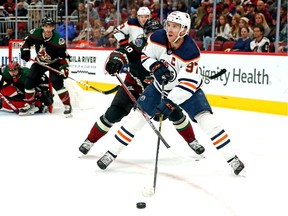 Edmonton Oilers center Connor McDavid (97) moves the puck against Arizona Coyotes center Barrett Hayton (29) during the first period at Gila River Arena.