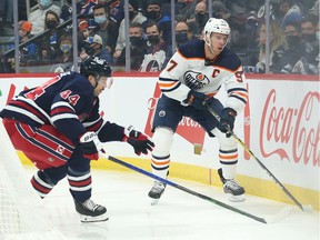 Nov 16, 2021; Winnipeg, Manitoba, CAN; Edmonton Oilers forward Connor McDavid (97) avoids the checking of Winnipeg Jets defenseman Josh Morrissey (44) during the first period at Canada Life Centre. Mandatory Credit: Terrence Lee-USA TODAY Sports