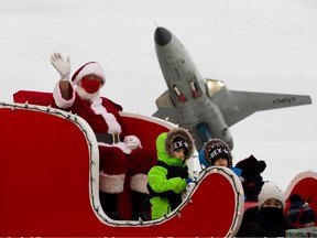 Santa waves to the crowd as he passes the  Alberta Aviatiion Museum  during the  Kingsway Holiday Parade as it makes its way to Kingsway Mall where Santa will be visiting.Taken on Sunday, Nov. 28, 2021  in Edmonton.  Greg Southam-Postmedia