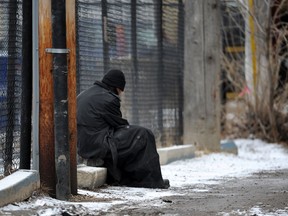 A homeless man sits in an inner city back alley in Edmonton. File photo.