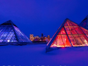Downtown lights can be seen behind the Muttart Conservatory pyramids on Wednesday, Nov. 17, 2021 in Edmonton. The conservatory is one of the facilities currently seeing service limitations due to the COVID-19 pandemic.