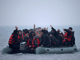 A group of more than 40 migrants on an inflatable dinghy leave the coast of northern France to cross the English Channel, near Wimereux, France, November 24, 2021. They arrived safely but 31 people died when another boat with migrants sank in the English Channel the same day.