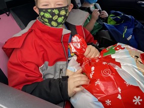 Little Santas Rylan and Graycen prepare to take home a gift they picked out for their mother Lennea at Kaleo Collective's gift tent last December.