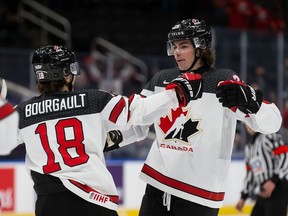 Xavier Bourgault (18) and Owen Power (25) of Canada celebrate a goal against Czechia in the first period during the 2022 IIHF World Junior Championship at Rogers Place on December 26, 2021.