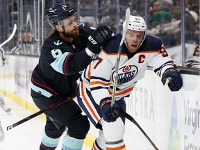 Adam Larsson #6 of the Seattle Kraken breaks his stick as Connor McDavid #97 of the Edmonton Oilers controls the puck during the first period at Climate Pledge Arena on December 18, 2021 in Seattle, Washington.