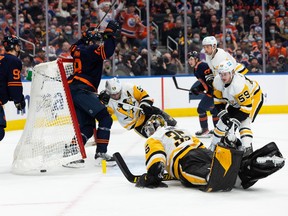 The Edmonton Oilers’ Zach Hyman (18) scores on Pittsburgh Penguins goaltender Tristan Jarry (35) at Rogers Place in Edmonton on Wednesday, Dec. 1, 2021. The goal, which was celebrated as a hat-trick, was disallowed.