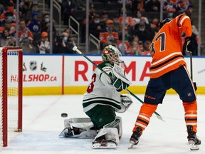Edmonton Oilers forward Warren Foegele (37) and Minnesota Wild’s goaltender Cam Talbot (33) reach for a flying puck during first period NHL action at Rogers Place in Edmonton, on Tuesday, Dec. 7, 2021.