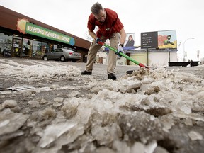 Dan Proctor shovels ice and slush out of the Earth's General Store parking lot, 9605 82 Ave., in Edmonton Wednesday Dec. 8, 2021. Photo by David Bloom