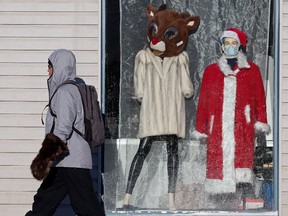 A pedestrian walks past a Christmas themed window display at the Bissell Thrift Shop, 8818 118 Ave., in Edmonton Friday Dec. 17, 2021. Photo by David Bloom