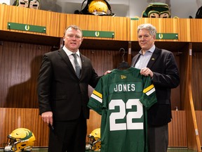 Chris Jones (left) gets a new jersey from Ian Murray, Edmonton Elks board of directors chair, during a press conference in the CFL team’s dressing room in Edmonton, on Tuesday, Dec. 21, 2021. Jones has been announced as the team’s new general manager and head coach.