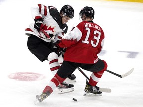 Team Canada's Cole Perfetti (11) battles Team Austria's Leon Wallner (13) during third period IIHF World Junior Hockey Championship action in Edmonton on Tuesday, Dec. 28, 2021.