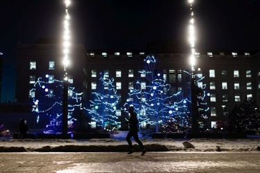 A runner passes a display of holiday lights during the annual Legislature Light-Up in Edmonton, on Thursday, Dec. 2, 2021. The event kicks off Celebrate the Season at the Alberta Legislature.