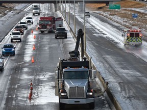 Crews working on the Whitemud Dr. eastbound which is still down to one lane after this mornings jack knifed truck that crashed into the concrete centre barrier due to the freezing rain in Edmonton, December 8, 2021.