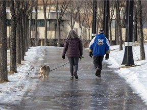 Sidewalks in the downtown river valley are coated in ice on Thursday, Dec. 9, 2021 in Edmonton.  these two walkers managed to stay upright using ice cleats on the bottom of their boots.