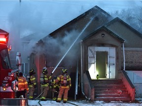 Smoke billows from out of this house as firefighter battle the blaze at this residence of 10931 97 St. in downtown Edmonton, December 11, 2021. Ed Kaiser/Postmedia